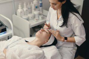 Facial beauty therapist performing facial on client