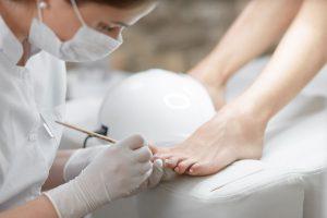 Qualified nail technician performing pedicure.